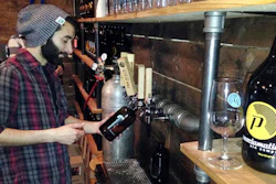 In this Friday, April 8, 2016 photo, Tom Pereira, tasting room manager at Proclamation Ale Co., fills a 32-ounce bottle of beer for a customer to take home during the release of a new beer in West Kingston, R.I. The ale house is urging lawmakers to remove the limit on the amount breweries can sell to visitors on site for consumption off premises.