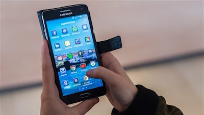 A woman uses an Android smartphone in Brussels on Wednesday April 20, 2016. The European Union is broadening its battle with Google, alleging that the technology giant rigs the global market for mobile apps by making its Android operating system give preferential treatment to its own products. EU Antitrust Commissioner Margrethe Vestager said that 'Google's behavior denies consumers a wider choice of mobile apps and services and stands in the way of innovation.'