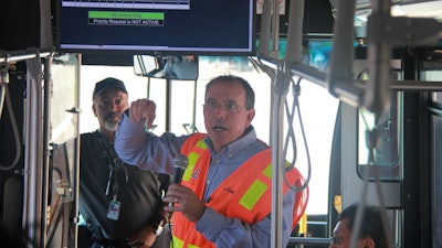 Transportation engineer Larry Head explains connected vehicle technology to bus riders before a demonstration in Anthem, Arizona. The data on the display monitor, based on UA-developed algorithms, alerts the driver to hazards.