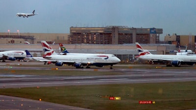 In this 2014 file photo, aircraft wait on the tarmac at Heathrow Airport in London. A collision between a British Airways passenger jet and a drone left the plane undamaged, but the aviation industry shaken. British police and air-accident authorities are investigating the incident.
