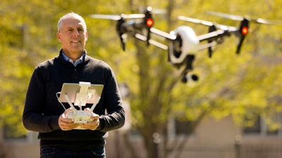 In this Thursday, April 14, 2016, photo, DroneLinx CEO Steve Metzman operates a drone to make videos and still images of an apartment building, in Philadelphia. DroneLinx, a service based in New York, takes shots of cellphone towers, bridges, oil rigs and utility lines that are difficult to get careful inspections of, Metzman says.