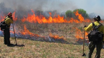 Fire crews keep watch over a controlled grass fire at the Homestead National Monument of America in Beatrice, Neb., on Friday, April 22, 2016. University of Nebraska-Lincoln researchers used the burn as a chance to test a drone that can start its own fires.