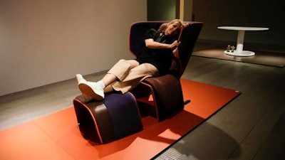 In this April 11, 2016 photo, Spanish designer Patricia Urquiola is lying on a chair called 'Gender,' during an interview with the Associated Press, at the Cassina space, part of the Design Fair exhibition, in Milan, Italy.