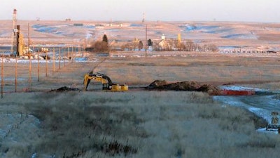 In this Jan. 12, 2015 file photo, crews dig at a spill site where a leak from a four-inch pipeline spilled nearly 3 million gallons of saltwater brine near Blacktail Creek outside Williston, N.D.