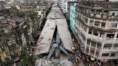 General view shows a partially collapsed overpass in Kolkata, India, Friday, April 1, 2016. The overpass spanned nearly the width of the street and was designed to ease traffic through the densely crowded Bara Bazaar neighborhood in the capital of the east Indian state of West Bengal. About 100 meters (300 feet) of the overpass fell, while other sections remained standing.