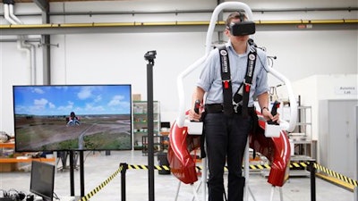 In this Feb. 9, 2016 photo, test pilot Michael van der Vliet operates a flight simulator at the Martin Aircraft Co. headquarters in Christchurch, New Zealand.