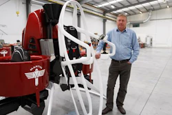 In this Feb. 9, 2016 photo, Martin Aircraft CEO Peter Coker stands next to a Martin Jetpack in Christchurch, New Zealand. The company says it’s close to commercial liftoff, but the man who started it fears his vision of a personal jetpack will remain grounded.