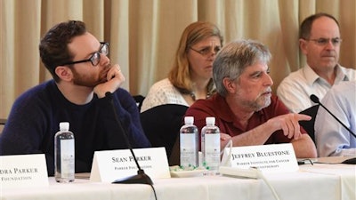 This April 4, 2016, photo provided by the Parker Institute shows from left, Sean Parker and Jeffery Bluestone at the Parker Institute for Cancer Immunotherapy Scientific Retreat in St. Helena, Calif. A project to speed development of cancer-fighting drugs that harness the immune system has academic and drug industry researchers collaborating and sharing their findings like never before.
