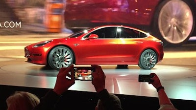 In this March 31, 2016 file photo, Tesla Motors unveils the new lower-priced Model 3 sedan at the Tesla Motors design studio in Hawthorne, Calif. More than 276,000 people pre-order the Tesla Model 3 in less than a week. Is it the “Tesla phenomenon,” or has the $35,000 electric car with a range of 200-plus miles taken finally taken the electric car to the masses.