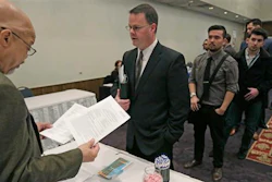 In this April 22, 2015 file photo, Ralph Logan, general manager of Microtrain, left, speaks with James Smith who is seeking employment during a National Career Fairs job fair in Chicago. U.S. employers notched another solid month of hiring in March by adding 215,000 jobs, driven by large gains in the construction, retail and health care industries. Despite the jump, the Labor Department said Friday, April 1, 2016 that the unemployment rate ticked up to 5 percent from 4.9 percent.