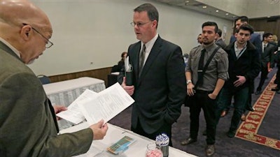 In this April 22, 2015 file photo, Ralph Logan, general manager of Microtrain, left, speaks with James Smith who is seeking employment during a National Career Fairs job fair in Chicago. U.S. employers notched another solid month of hiring in March by adding 215,000 jobs, driven by large gains in the construction, retail and health care industries. Despite the jump, the Labor Department said Friday, April 1, 2016 that the unemployment rate ticked up to 5 percent from 4.9 percent.