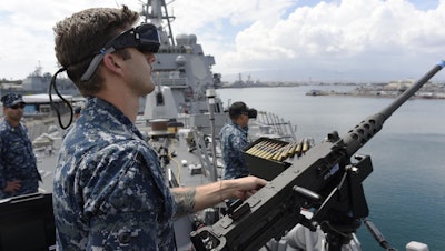 Gunners Mate 2nd Class Daniel Green, foreground, and Fire Controlman 3rd Class Tong Vang, right, defend against virtual enemy combatants during an Office of Naval Research (ONR) demonstration of new and improved virtual training programs that combine software and gaming technology to help naval forces plan for multiple missions and operations.