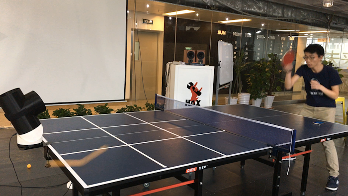 Harrison Chen plays ping pong with the robotic table tennis trainer prototype in Shenzhen, China.