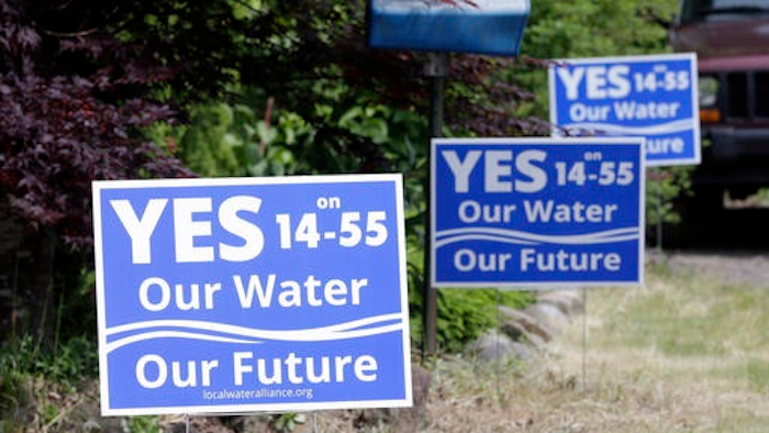 FILE - In this May 5, 2016 file photo, ballot measure yard signs regarding the issue of moving a Nestle spring water bottling plant into the small community, are shown in Cascade Locks, Ore. Oregon's scenic Columbia River Gorge is the stage for one of the hottest disputes in Oregon's Tuesday, May 17, 2016 primary — a proposal by Nestle to build a bottled water plant in Cascade Locks, using water from a mountain spring.