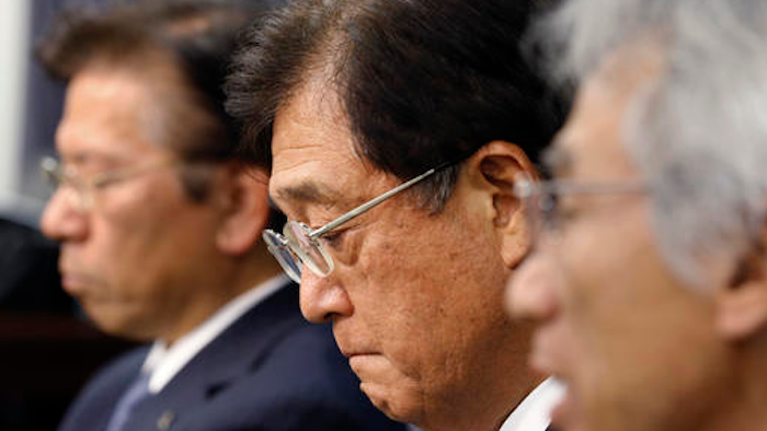 Mitsubishi Motors Corp. Chairman Osamu Masuko, center, listens to a reporter's question with President Tetsuro Aikawa, left, and Vice President Ryugo Nakao during a press conference in Tokyo, Wednesday, May 18, 2016. Aikawa said Wednesday that he will step down to take responsibility for the mileage cheating scandal unfolding at the Japanese automaker.