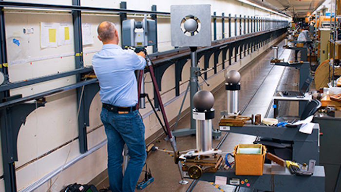 A participant performing relative range measurements in the long length tape tunnel facility at NIST.