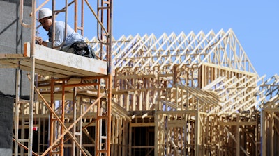 In this file photo, a carpenter works on the siding of a new townhouse. On Monday, May 16, 2016, the National Association of Home Builders/Wells Fargo releases its May index of builder sentiment.