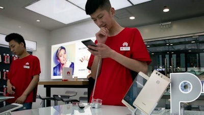 Chinese sales representatives wait for customers at a Huawei retails shop in Beijing, China. Chinese tech giant Huawei said Wednesday, May 25 it has filed patent infringement lawsuits against South Korean mobile phone rival Samsung in the United States and China, in a case that highlights the rise of Asian competitors as technology creators.