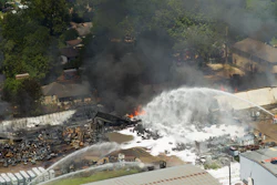 Firefighters pour water on a four-alarm fire at a custom packing and filling company in west Houston. The blaze caused various explosions that rattled the industrial area and surrounding neighborhoods.