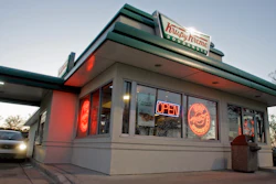 In this file photo, a customer picks up doughnuts at the drive through at a Krispy Kreme store in Matthews, N.C. Krispy Kreme is being taken private by JAB Beech.