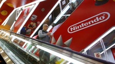 In this file photo, a shopper passes by the Nintendo logo at an electronics store in Tokyo. The Japanese video game maker is eyeing the movie business for growth.