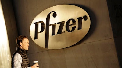 In this file photo, a man enters Pfizer's world headquarters, in New York. Pfizer is buying Anacor Pharmaceuticals Inc. in a deal announced Monday, May 16, 2016.