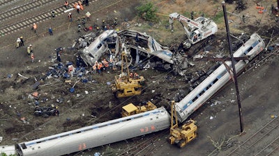 In this Wednesday, May 13, 2015 file photo, emergency personnel work at the scene of a Tuesday night derailment in Philadelphia of an Amtrak train headed to New York. The National Transportation Safety Board is scheduled to meet Tuesday, May 17, 2016, to detail the probable cause of last year's fatal derailment.