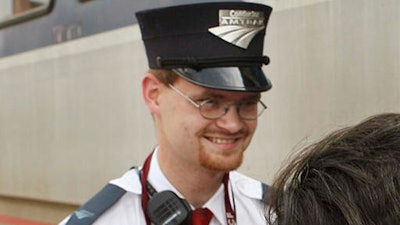 In this Aug. 21, 2007, file photo, Amtrak assistant conductor Brandon Bostian stands outside a train at the Amtrak station in St. Louis. Bostian was the engineer during the fatal May 12, 2015, Amtrak passenger train derailment in Philadelphia. Victims of the derailment aren’t buying the findings of federal investigators that the train’s engineer likely lost his bearings because he was distracted by an incident with a nearby train.