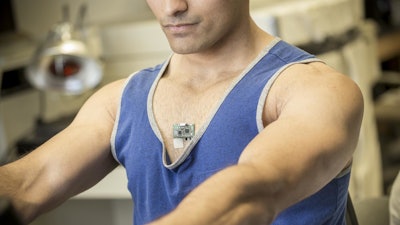 Study co-author Amay Bandodkar wears the ChemPhys patch while using an exercise bike in a lab at the Center for Wearable Sensors.