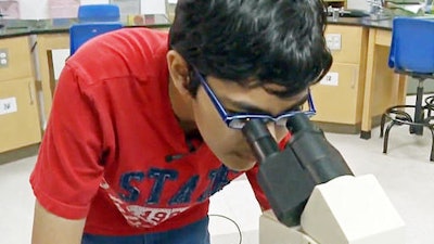 In this recent but undated frame from video provided by KOVR-TV, Tanishq Abraham, 12, looks into a microscope in a lab at American River College in Sacramento, Calif., during an interview about his recent graduation from community college and beginning his university education this fall. He's been accepted to the University of California, Davis, and UC Santa Cruz. He says he plans on studying biomedical engineering and becoming a doctor and medical researcher by the time he turns 18.