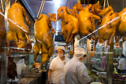 In this Wednesday, Nov. 11, 2015, photo, a worker prepares cooked ducks for sale at a Wal-Mart in Shenzhen, in southern China's Guangdong province. If Arkansas-based Wal-Mart wants to win over foreign consumers, it has to shed some of its American ways, and cater to very different customs and conventions. China is the ultimate prize.