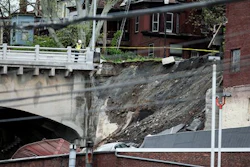 A member of emergency crews looks at a collapsed retaining wall of the Mulberry Street bridge in Harrisburg, Pa., Thursday, May 5, 2016.