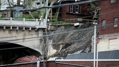 A member of emergency crews looks at a collapsed retaining wall of the Mulberry Street bridge in Harrisburg, Pa., Thursday, May 5, 2016.