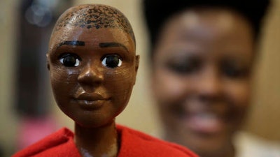 In this Tuesday, April 26, 2016 photo, Jennifer Pierre, of Fort Lauderdale, Fla., a student at Babson College, displays her prototype doll named Jaylen in a workroom at the school, in Wellesley, Mass. Pierre is launching a new line of dolls intended for boys of color.