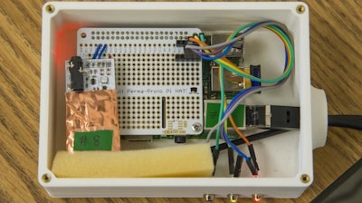 A DoseNet device consists of a 3-D-printed case, a Raspberry Pi computer circuit board (upper left), a small radiation sensor (coated in copper foil at lower left), and an Internet cable connection (at right).