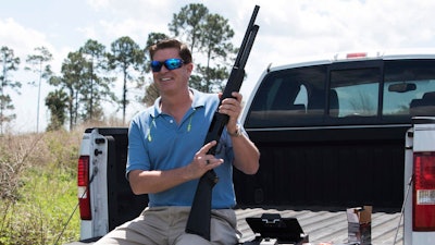 In this photo taken April 7, 2016, Jonathan Mossberg, whose iGun Technology Corp. is working to develop a 'smart gun,' poses with the firearm, in Daytona Beach, Fla. Mossberg is among a group of pioneers looking to build a safer gun. But unlike many others, he was in the gun business when he started down that path. Mossberg has been working to develop and someday bring to market a firearm that can't be fired by the wrong person, but works without fail in the hands of its owner in a life-or-death situation.