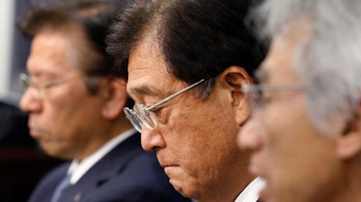 Mitsubishi Motors Corp. Chairman Osamu Masuko, center, listens to a reporter's question with President Tetsuro Aikawa, left, and Vice President Ryugo Nakao during a press conference in Tokyo, Wednesday, May 18, 2016. Aikawa said Wednesday that he will step down to take responsibility for the mileage cheating scandal unfolding at the Japanese automaker.