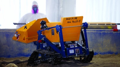 A robot miner traverses the simulated Martian regolith in the mining area during NASA’s 6th Annual Robotic Mining Competition at the Kennedy Space Center Visitor Complex.