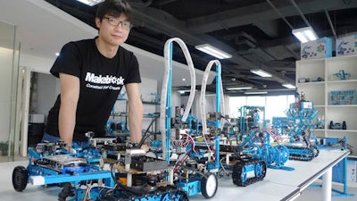In this April 20, 2016 photo, Jasen Wang, founder of Shenzhen educational robot company Makeblock, poses with some of his company's products in Shenzhen, China. Once a collection of fishing enclaves next door to Hong Kong, Shenzhen has become the epicenter of China’s manufacturing-driven miracle is staking its future growth on finance, technology and culture.