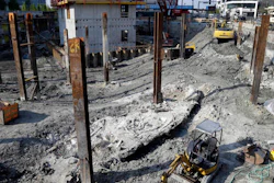 A shipwreck from the 1800s that has been uncovered during construction in the Seaport District is seen to the left of a construction vehicle, bottom, Wednesday, May 25, 2016, in Boston. According to city archaeologist Joe Bagley, it's the first time a shipwreck has been found in this section of Boston. Bagley says it appears the vessel was carrying lime, which was used for masonry and construction.