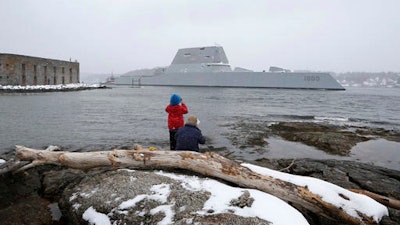 n this March 21, 2016 file photo, Dave Cleaveland and his son, Cody, photograph the USS Zumwalt as it passes Fort Popham at the mouth of the Kennebec River in Phippsburg, Maine, as it heads to sea for final builder trials. The ship is so stealthy that the U.S. Navy resorted to putting reflective material on its halyard to make it visible to mariners during the trials.