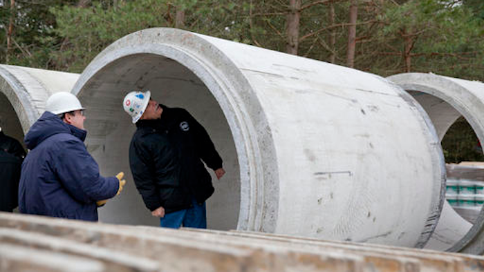 In this Nov. 26, 2013 file photo, Karegnondi Water Authority CEO Jeff Wright, right, and Deputy CEO John O'Brien look inside a pipe that will be part of the Karegnondi Pipeline Project, in Worth Township, Mich. After months of national attention on lead-tainted drinking water in Flint, many are starting to ask questions about the 74-mile pipeline being built from Lake Huron to the struggling former auto manufacturing powerhouse.