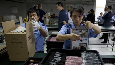 In this Tuesday, Nov. 10, 2015, photo, workers at Alco Electronics pack video display devices at the factory in Houjie Town, Dongguan City, in the Guangdong province of China. A look inside the factory shows what it takes to succeed as a maker of gadgets for the rest of the world: Human precision in tiny tasks, increasingly automated manufacturing, but also flexible thinking and perks to keep the best employees.