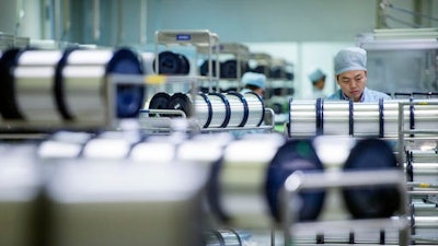 A staff member works in the workshop of an optical fiber and cable manufacturing company in Wuhan in central China's Hubei province. China's factory activity was feeble last month, according to two surveys released Wednesday, June 1, 2016, indicating that official efforts to reverse a downturn in the world's second-biggest economy are struggling.