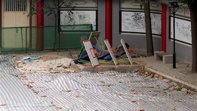 A tarp covers the ground after a running track suspected to be made from toxic material was removed from the Beijing No. 2 Experimental School near in Beijing, China, Thursday, June 23, 2016. Schools across China have been ordered to remove running tracks made from toxic materials that have been blamed for sickening students, in the latest in a long line of product scandals blamed on corruption and weak oversight.