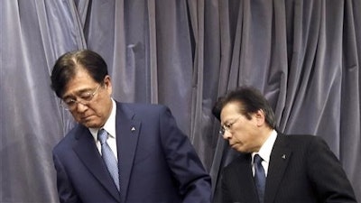 In this May 11, 2016 photo, Mitsubishi Motors Corp. Chairman and CEO Osamu Masuko, left, and President Tetsuro Aikawa prepare for their press conference in Tokyo. Mitsubishi Motors Corp., which recently acknowledged it inflated mileage for its models, is forecasting a 145 billion yen ($1.4 billion) loss for the fiscal year through March 2017.