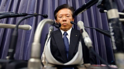 In this file photo, Mitsubishi Motors Corp. President Tetsuro Aikawa listens to a reporter's question during a press conference in Tokyo.