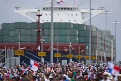 Thousands of spectators watch as the Neopanamax cargo ship, Cosco Shipping Panama, makes its way through the new Agua Clara locks, part of the Panama Canal expansion project, near the port city of Colon, Panama, Sunday June 26, 2016. The ship carrying more than 9,000 containers entered the newly expanded locks that will double the Panama Canal's capacity in a multibillion-dollar bet on a bright economic future despite tough times for international shipping.