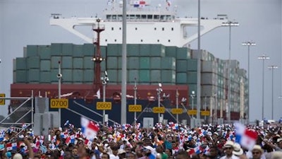 Thousands of spectators watch as the Neopanamax cargo ship, Cosco Shipping Panama, makes its way through the new Agua Clara locks, part of the Panama Canal expansion project, near the port city of Colon, Panama, Sunday June 26, 2016. The ship carrying more than 9,000 containers entered the newly expanded locks that will double the Panama Canal's capacity in a multibillion-dollar bet on a bright economic future despite tough times for international shipping.