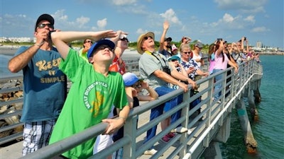 The Kopp family from Pennsylvania, foreground, watch the launch of the SpaceX Falcon 9 rocket from Cape Canaveral Air Force Station from the fishing pier Wednesday, June 15, 2016, in Port Canaveral, Fla. A leftover SpaceX rocket booster crashed Wednesday while trying to land on an ocean barge after the Falcon 9 rocket successfully launched two satellites from Cape Canaveral, Florida.
